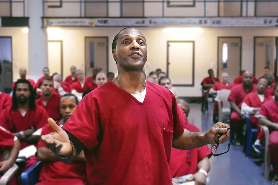 Incarcerated individual standing with arms outstretched during service